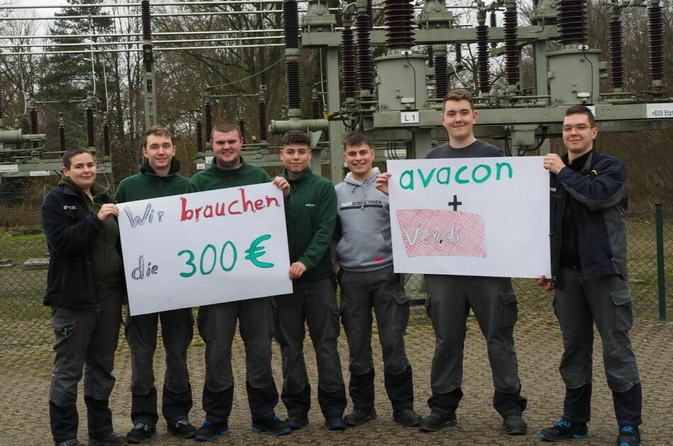 Nachwuchskräfte halten Schilder mit den Forderungen für die Tarifrunde hoch: Wir brauchen die 300 €! avacon + verdi!